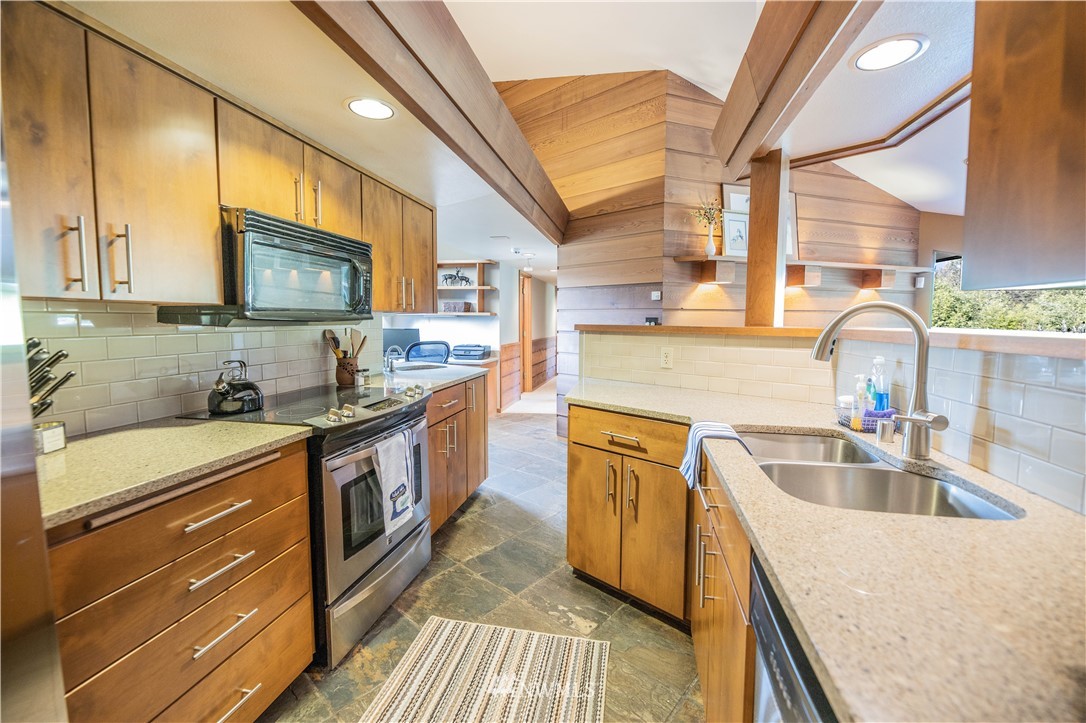 36815 Mann Road Sultan, WA 98294 - Photo 12 of 38 a kitchen with stainless steel appliances granite countertop a sink a stove and a wooden floors