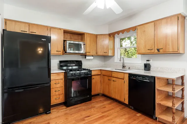 a kitchen with stainless steel appliances granite countertop a refrigerator a stove a sink and a microwave