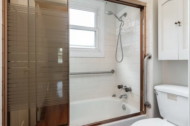a bathroom with a granite countertop bathtub shower and toilet