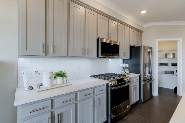 a kitchen with stainless steel appliances granite countertop a stove a refrigerator and a sink
