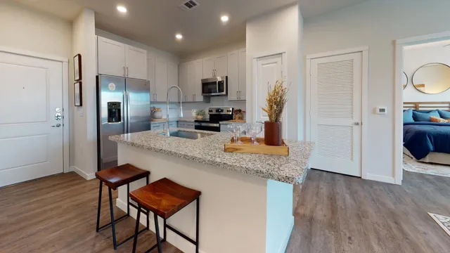 a kitchen with stainless steel appliances granite countertop a microwave a stove a sink and a refrigerator