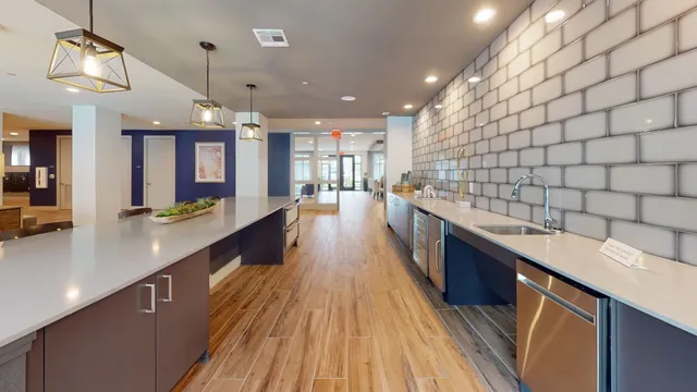 a large kitchen with kitchen island a large counter space a sink a window and stainless steel appliances