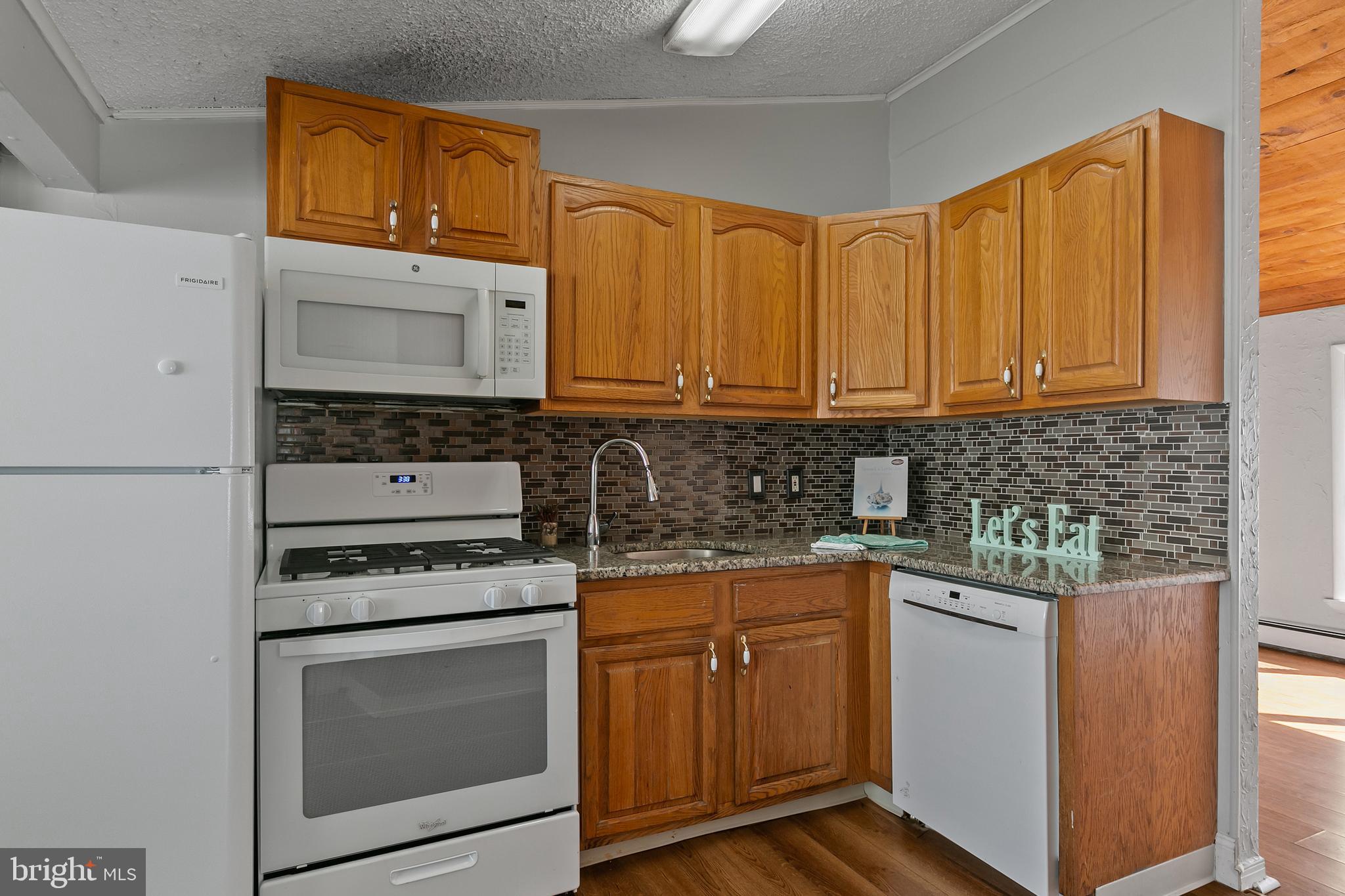 523 Estate Road Maple Shade, NJ 08052 - Photo 9 of 30 a kitchen with stainless steel appliances granite countertop a stove microwave and cabinets