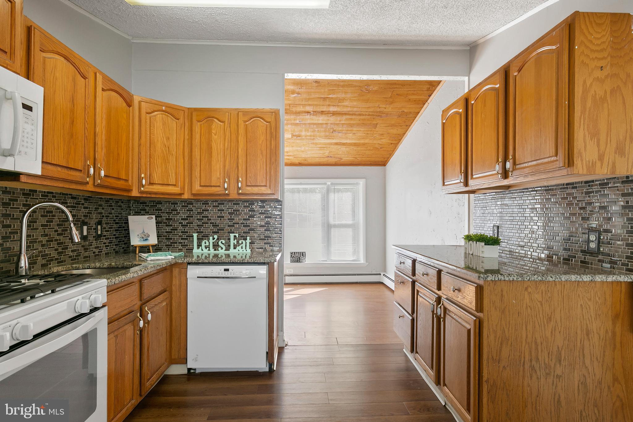 523 Estate Road Maple Shade, NJ 08052 - Photo 10 of 30 a kitchen with stainless steel appliances granite countertop wooden cabinets a sink and dishwasher a stove top oven with wooden floor