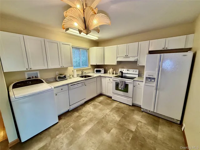 a kitchen with cabinets stainless steel appliances and a window