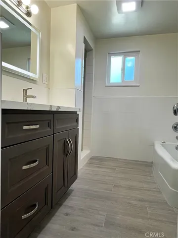 a bathroom with a sink a mirror and a bathtub