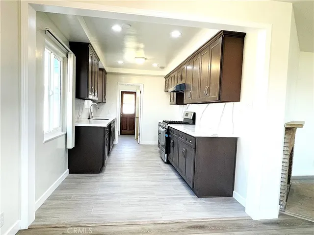 a large white kitchen with wooden floor