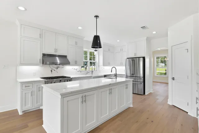 a kitchen with stainless steel appliances granite countertop a sink stove and refrigerator