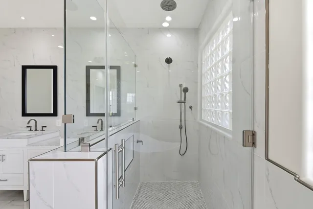 a bathroom with double vanity and a mirror