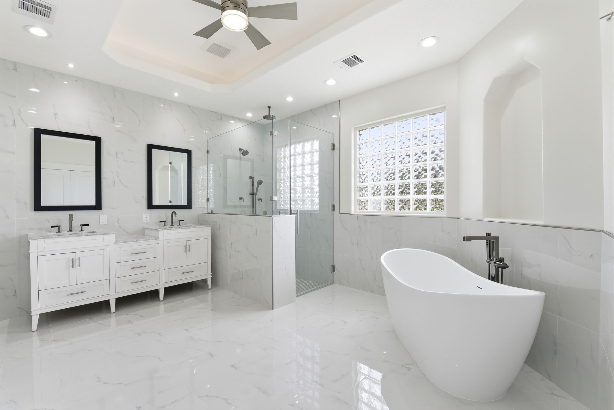 2819 Pearce Meadow Rosharon, TX 77583 - Photo 21 of 50 a bathroom with a double vanity sink a mirror a bathtub and a window