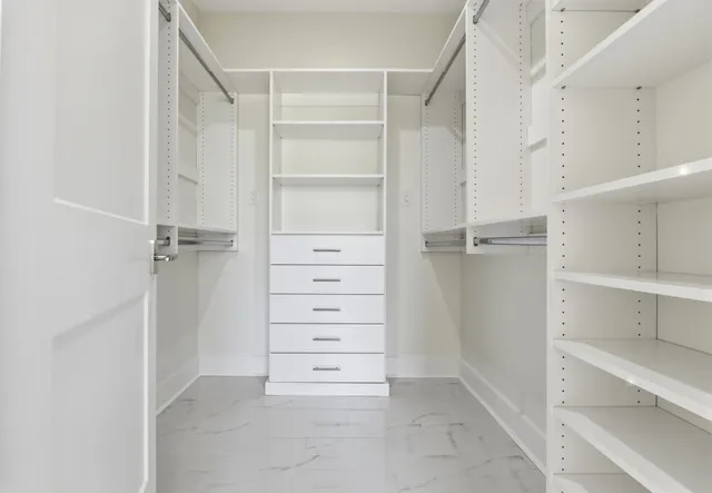 a view of walk in closet with empty racks
