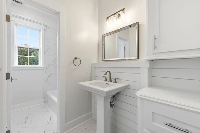 a bathroom with a sink a toilet and mirror