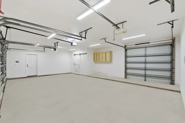 an empty room with ceiling fan and windows