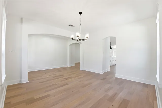 a view of a room with wooden floor a ceiling fan and a window