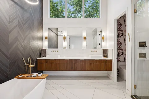 a bathroom with a tub a sink and mirror