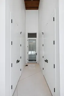 a view of a hallway with wooden floor and a window