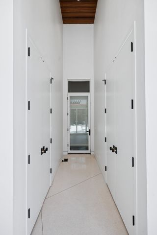a view of a hallway with wooden floor and a window