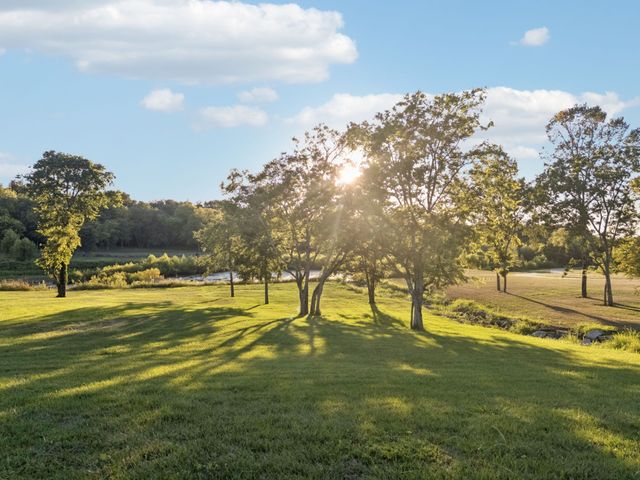a view of a house with backyard fountain and a garden
