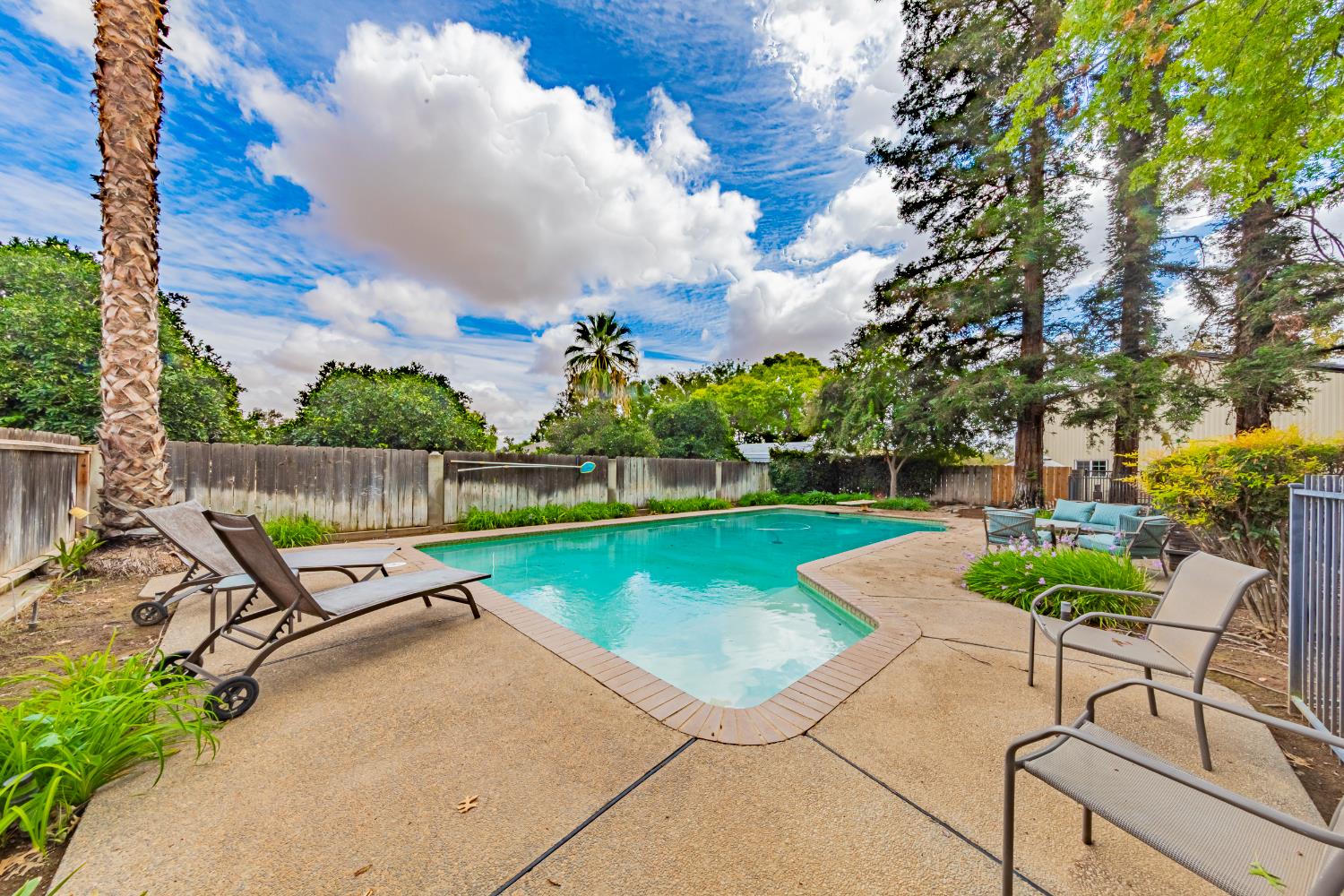 4449 Stetson Road Clovis, CA 93619 - Photo 68 of 93 a view of a swimming pool with a garden and seating area