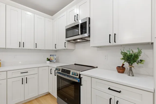 a kitchen with stainless steel appliances white cabinets and a stove