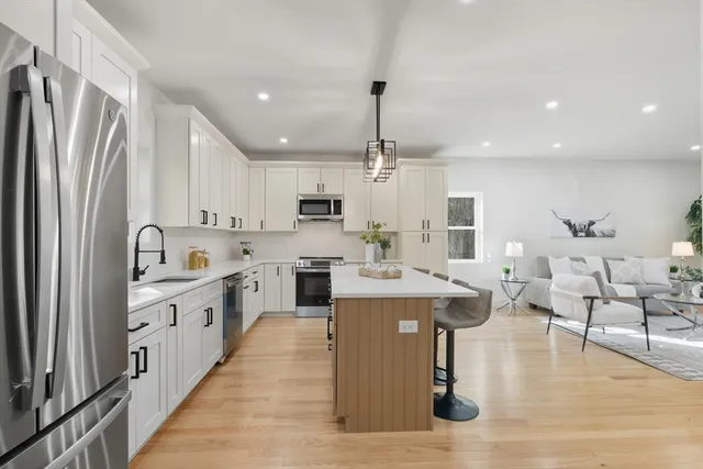 a large kitchen with stainless steel appliances lots of counter space and windows