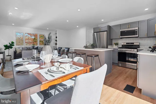 a dining room with stainless steel appliances a table and chairs