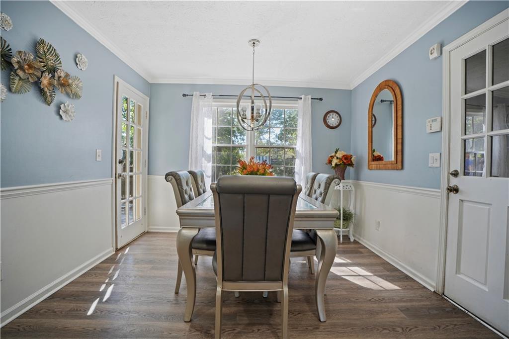 4880 Racquet Court Duluth, GA 30096 - Photo 13 of 22 a dining room with furniture a chandelier and wooden floor