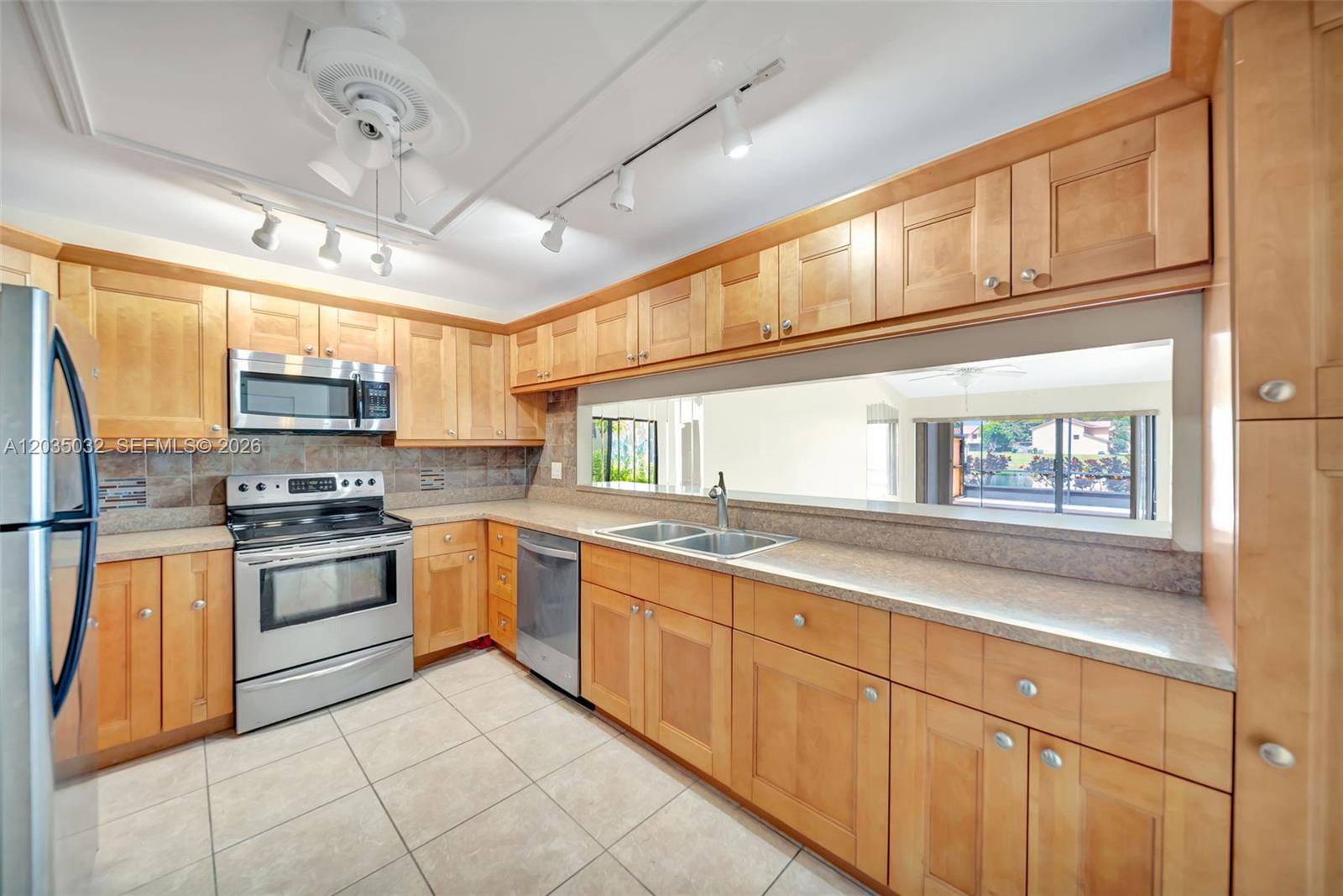 5223 Gate Lake Road, Unit 5223 Tamarac, FL 33319 - Photo 12 of 37 a kitchen with stainless steel appliances granite countertop a stove sink and cabinets