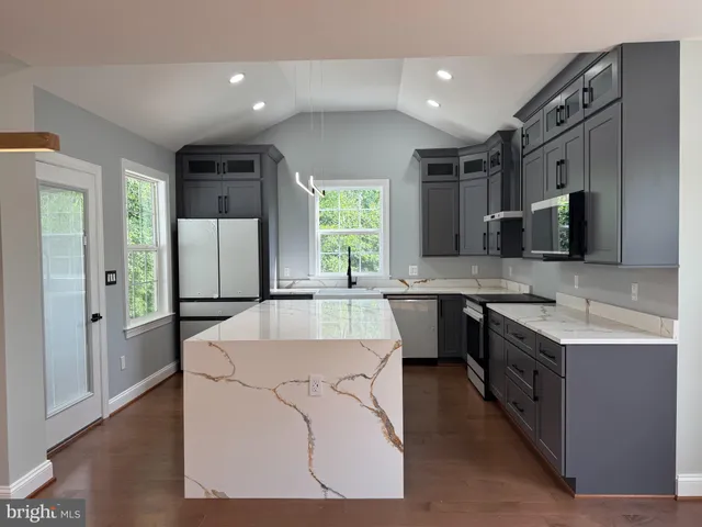 a large kitchen with kitchen island a sink stainless steel appliances and cabinets