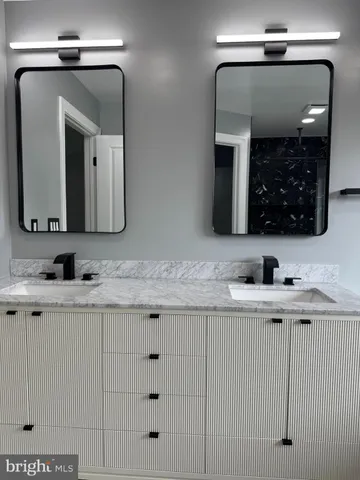 a bathroom with double sink and a mirror