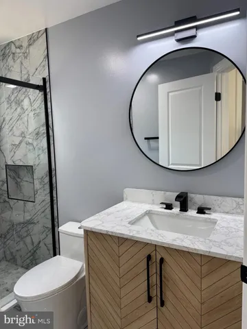 a bathroom with a toilet a sink and mirror