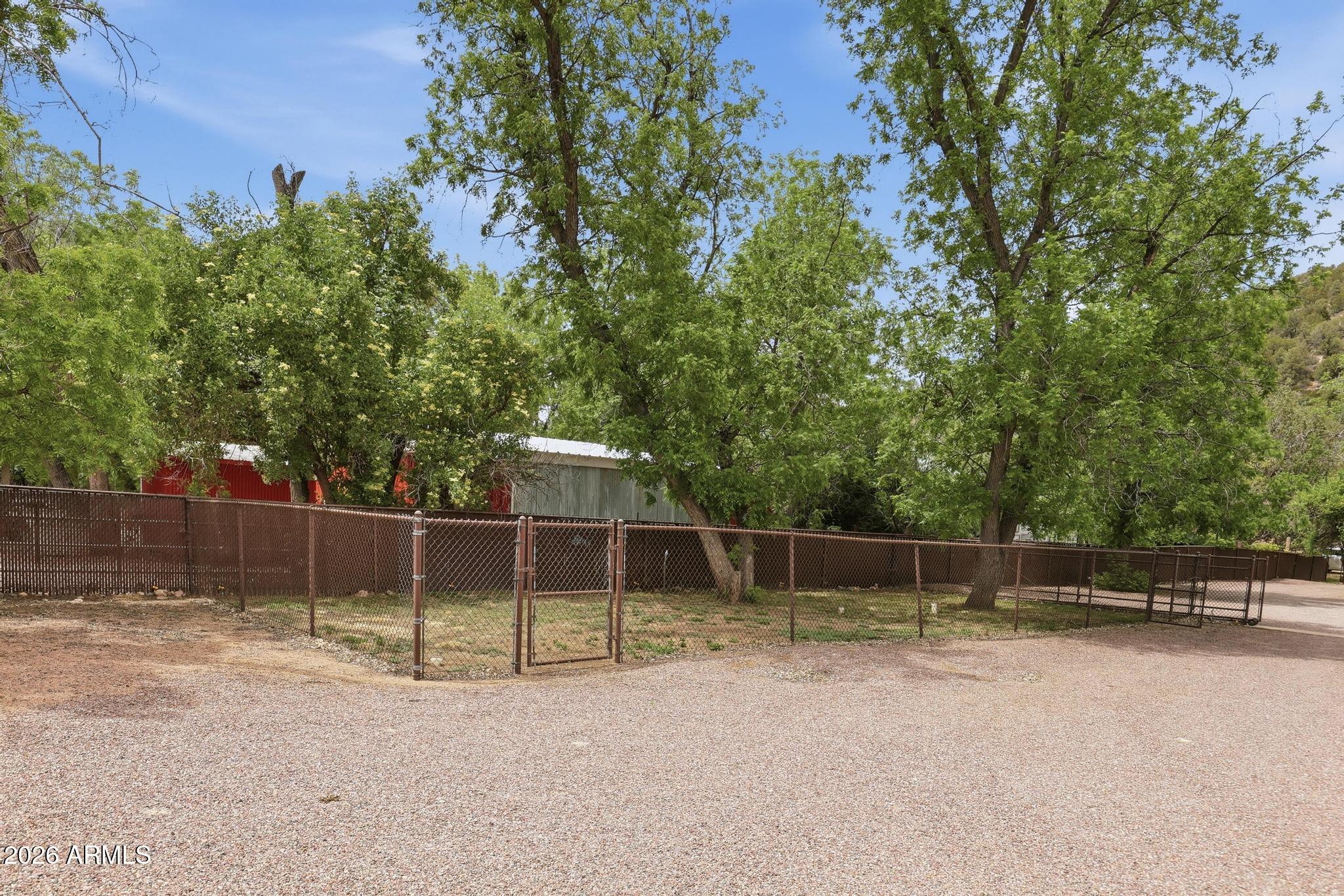7736 West Gibson Ranch Road Payson, AZ 85541 - Photo 40 of 51 a view of a backyard with large trees and wooden fence