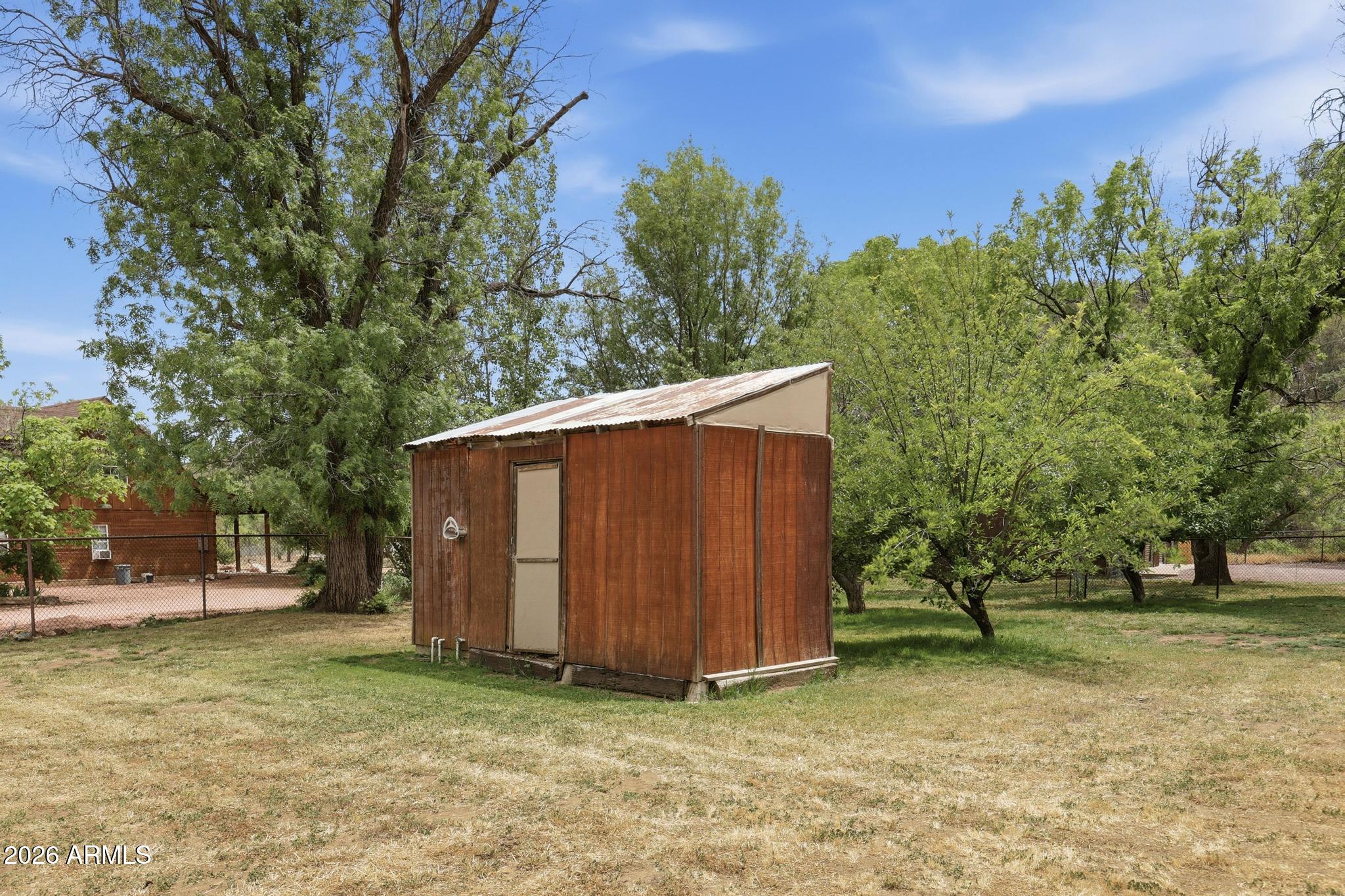 7736 West Gibson Ranch Road Payson, AZ 85541 - Photo 47 of 51 a view of a backyard with large trees and wooden fence