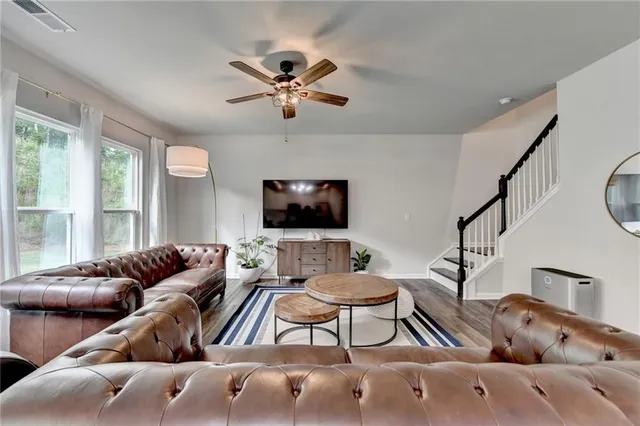 a living room with furniture ceiling fan and a flat screen tv