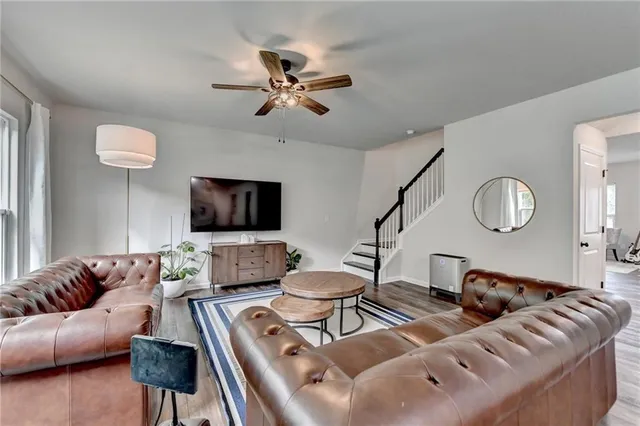 a living room with furniture a ceiling fan and a rug