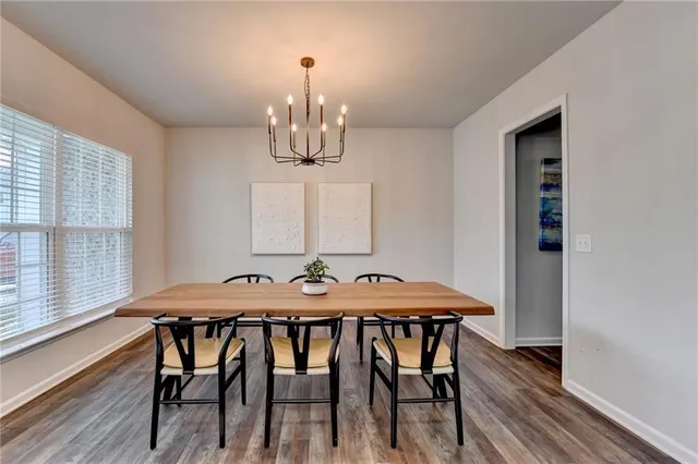 a view of a dining room with furniture a chandelier and wooden floor