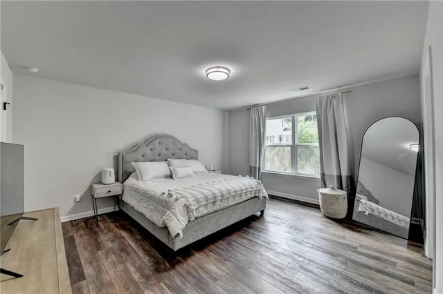 a bedroom with a bed chandelier and a window