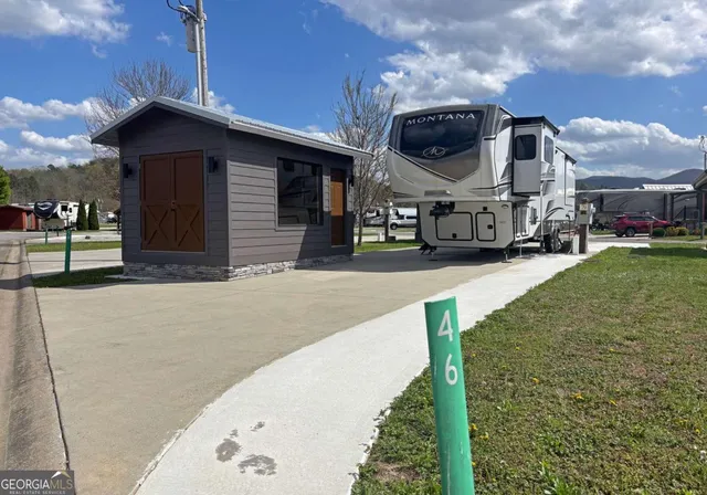 a view of a big house with wooden fence