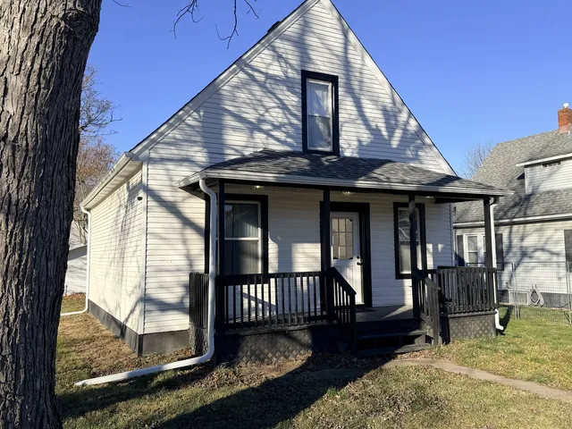 a front view of a house with glass windows and table