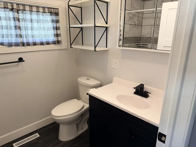 a bathroom with a toilet sink and mirror