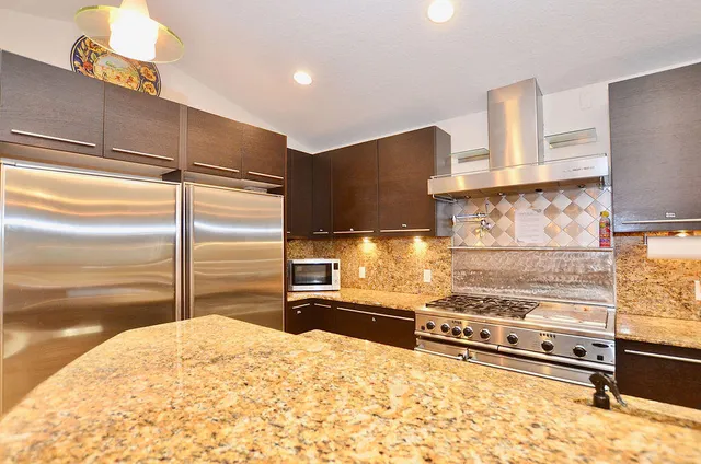 a kitchen with granite countertop a refrigerator and a stove