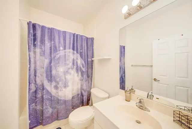 a bathroom with a sink a toilet and shower curtain