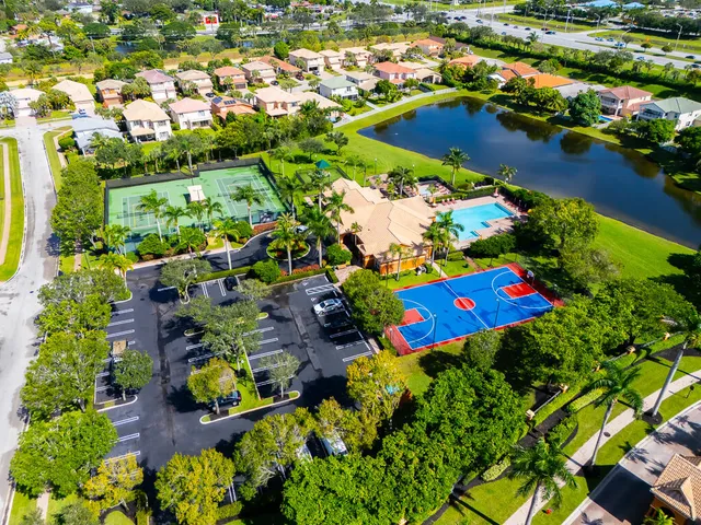 an aerial view of a house with a yard and lake view in back