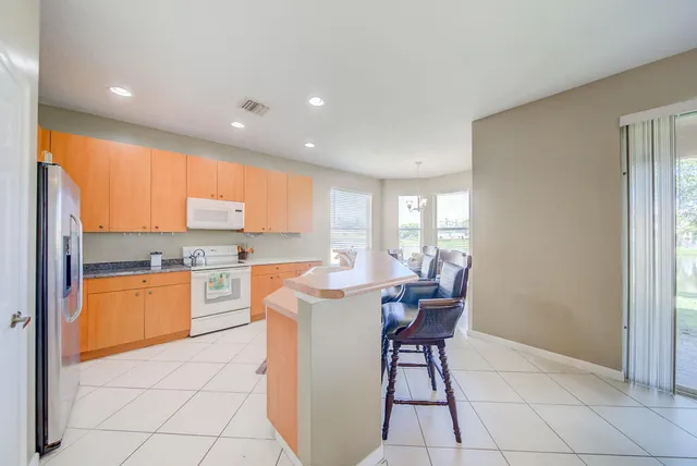 a dining hall with stainless steel appliances a dining table and chairs