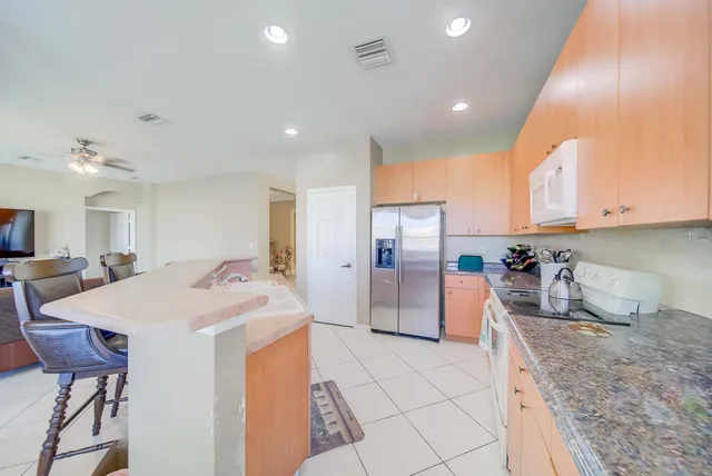 a kitchen with stainless steel appliances kitchen island granite countertop a sink and cabinets