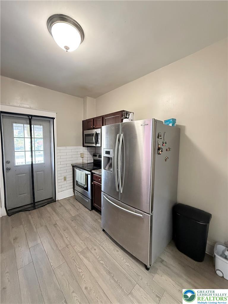 1025 Spring Street Bethlehem, PA 18018 - Photo 8 of 20 A well-lit kitchen features modern stainless steel appliances and wood-look flooring.