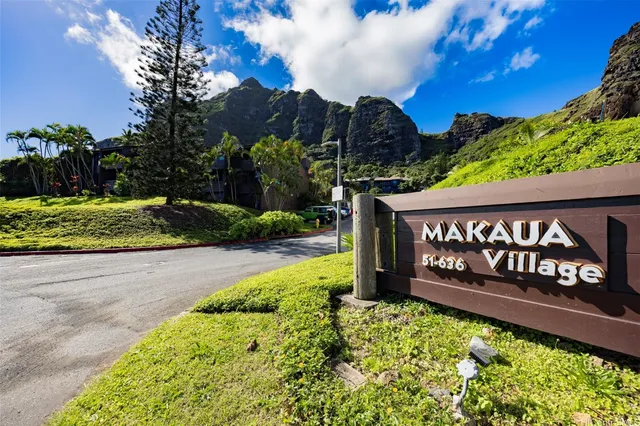 a view of a street sign under a large tree