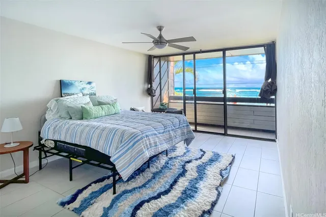 a bedroom with a bed and large window with view of balcony