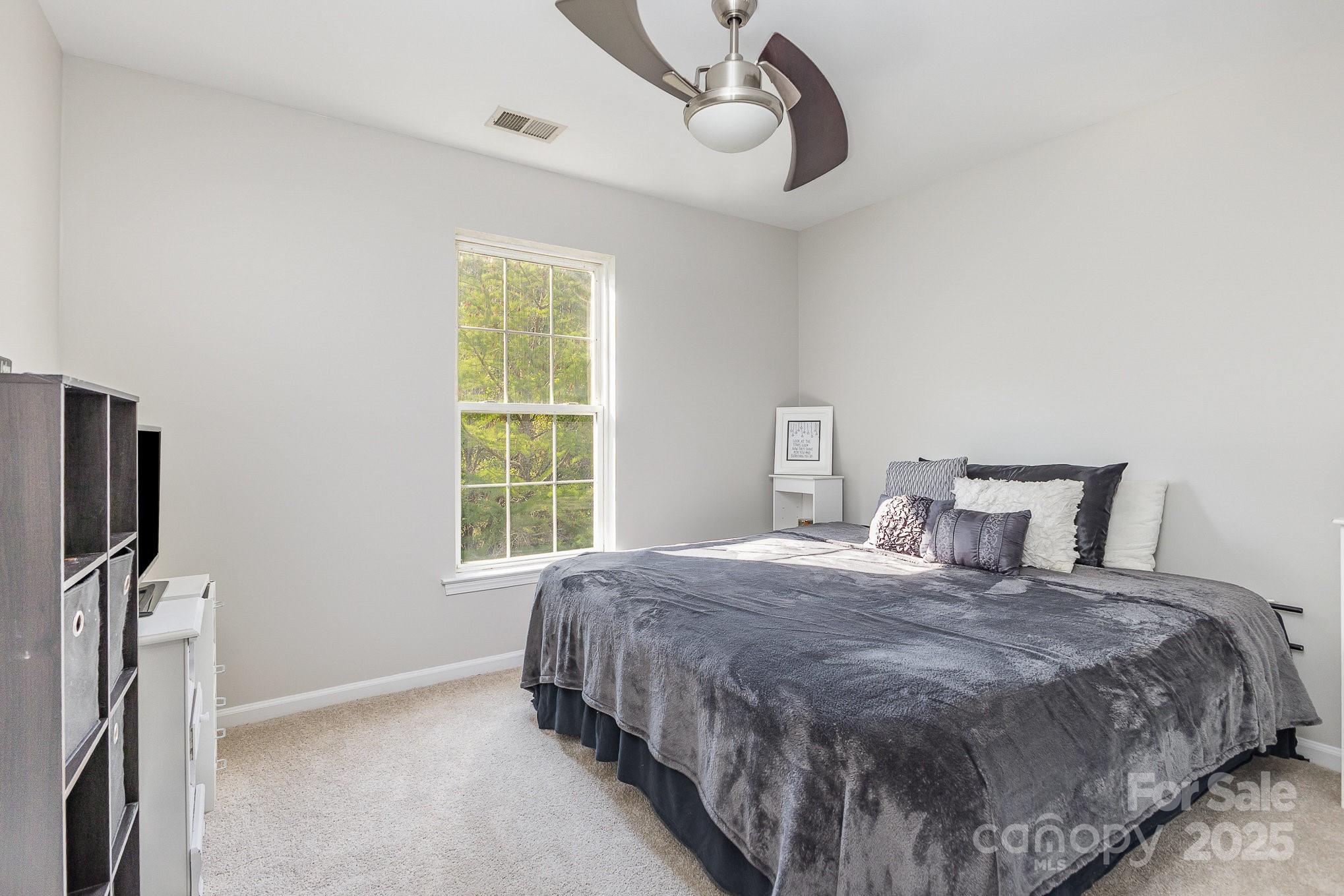 815 Clearbrook Road Matthews, NC 28105 - Photo 18 of 45 a bedroom with a bed flat screen tv and a window
