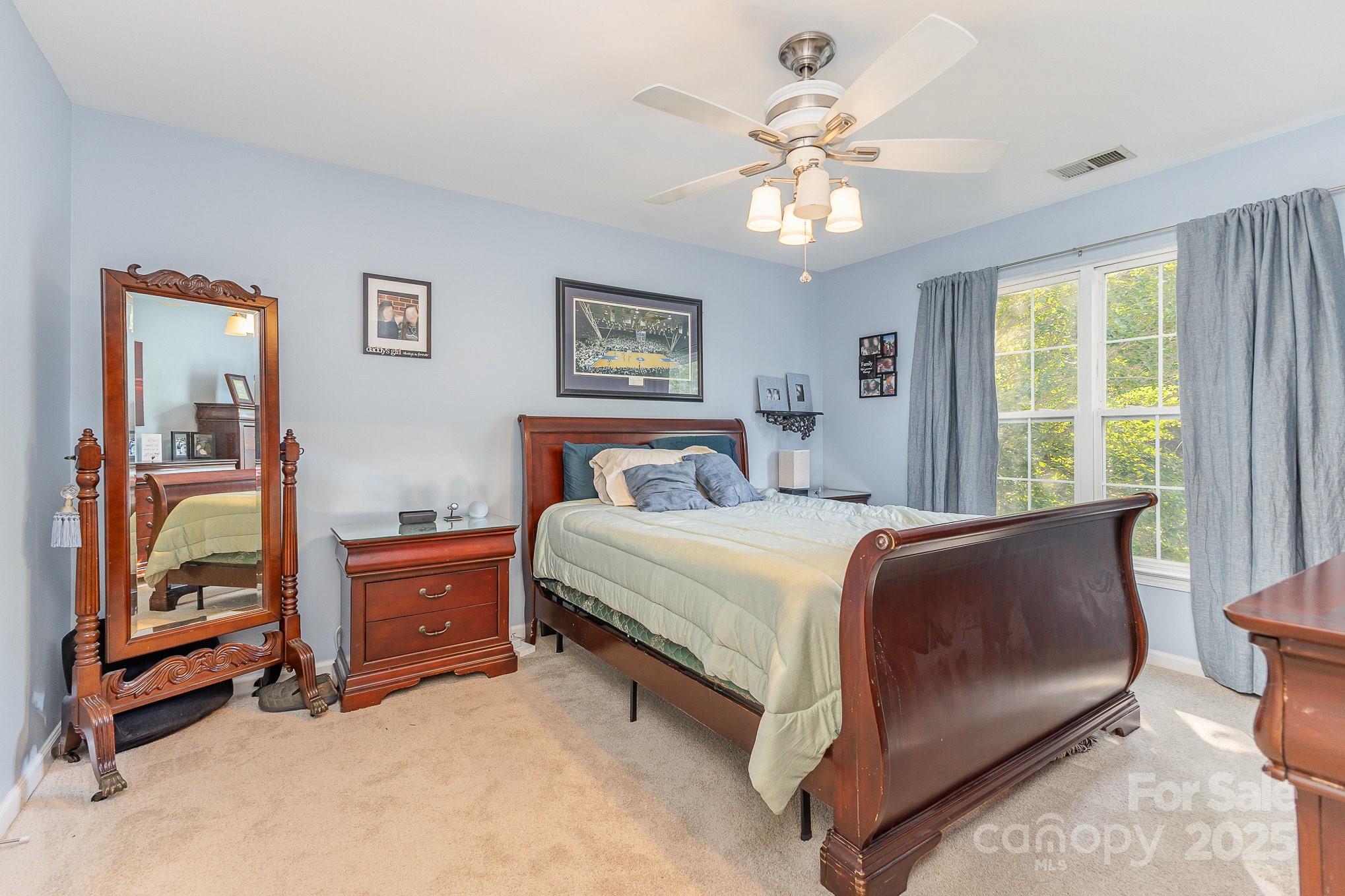 815 Clearbrook Road Matthews, NC 28105 - Photo 20 of 45 a bedroom with a bed and a chandelier